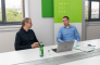 The entimo management team in a discussion at a conference table.