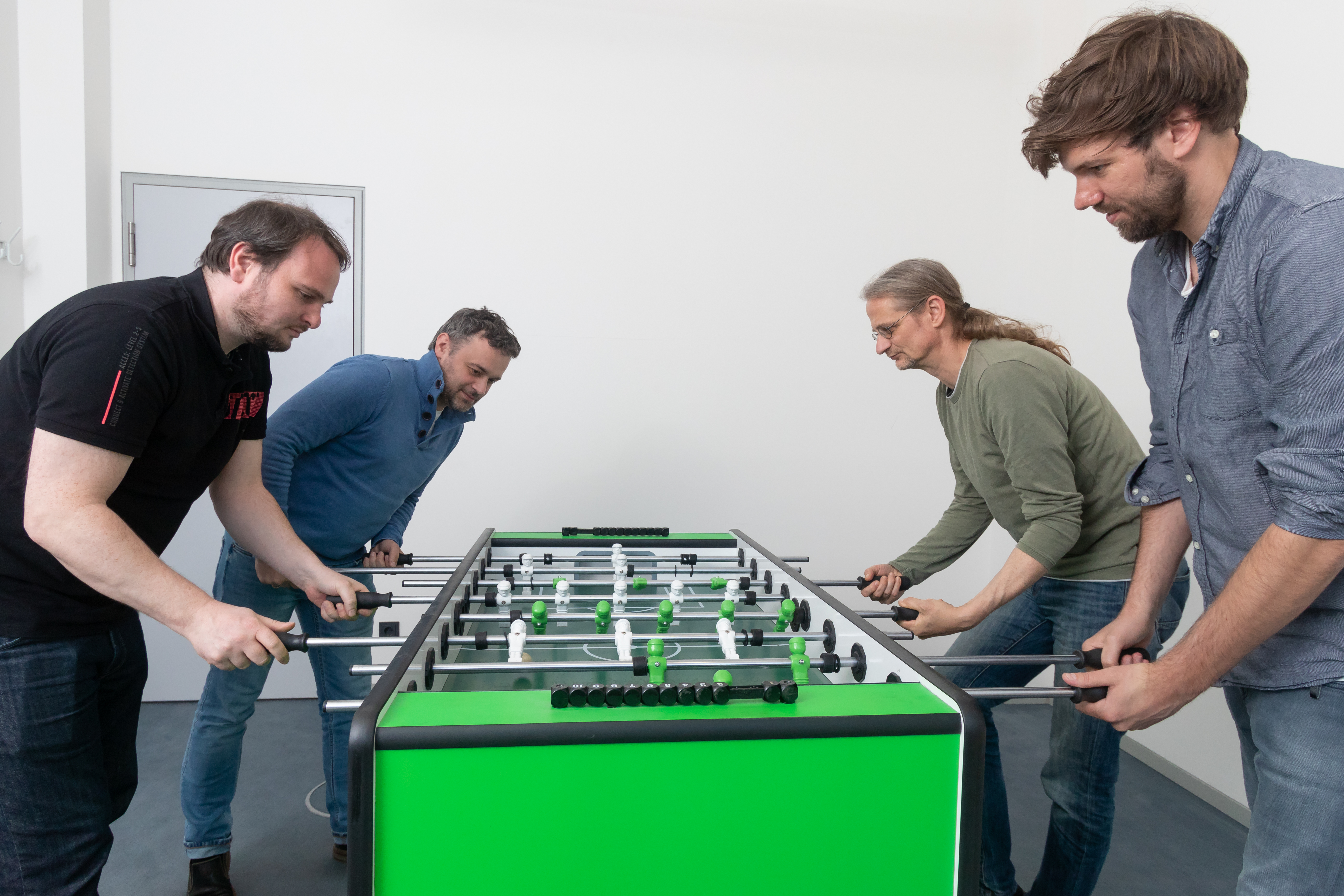 entimo colleagues enjoying a table football match during their lunch break