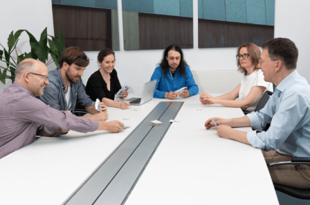 Six members of entimo's team in a discussion at a conference table.