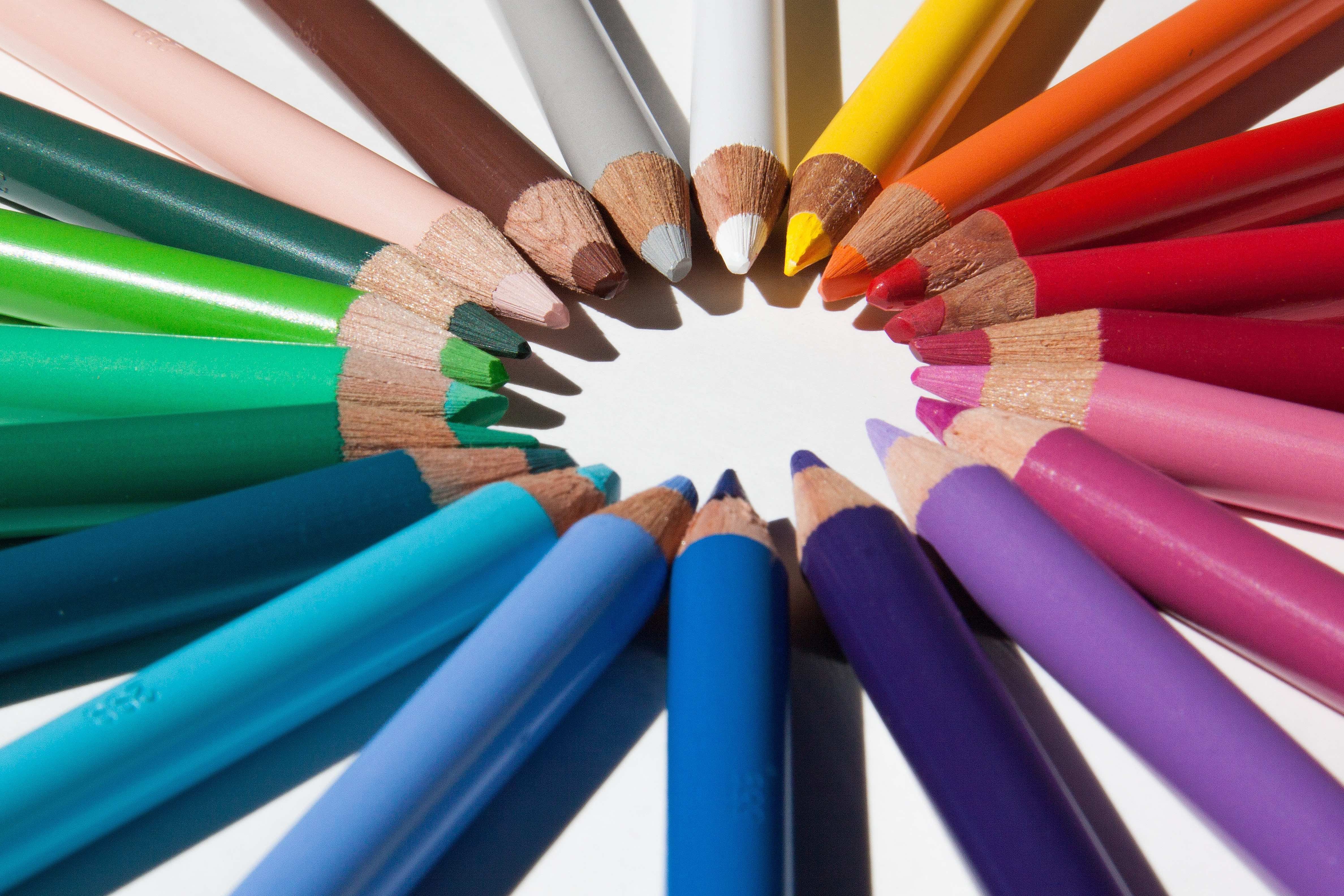 A group of about 20 pencils, each of a different color, form a circle with their tips and the bodies of the pencils running outward to the edges of the photo.