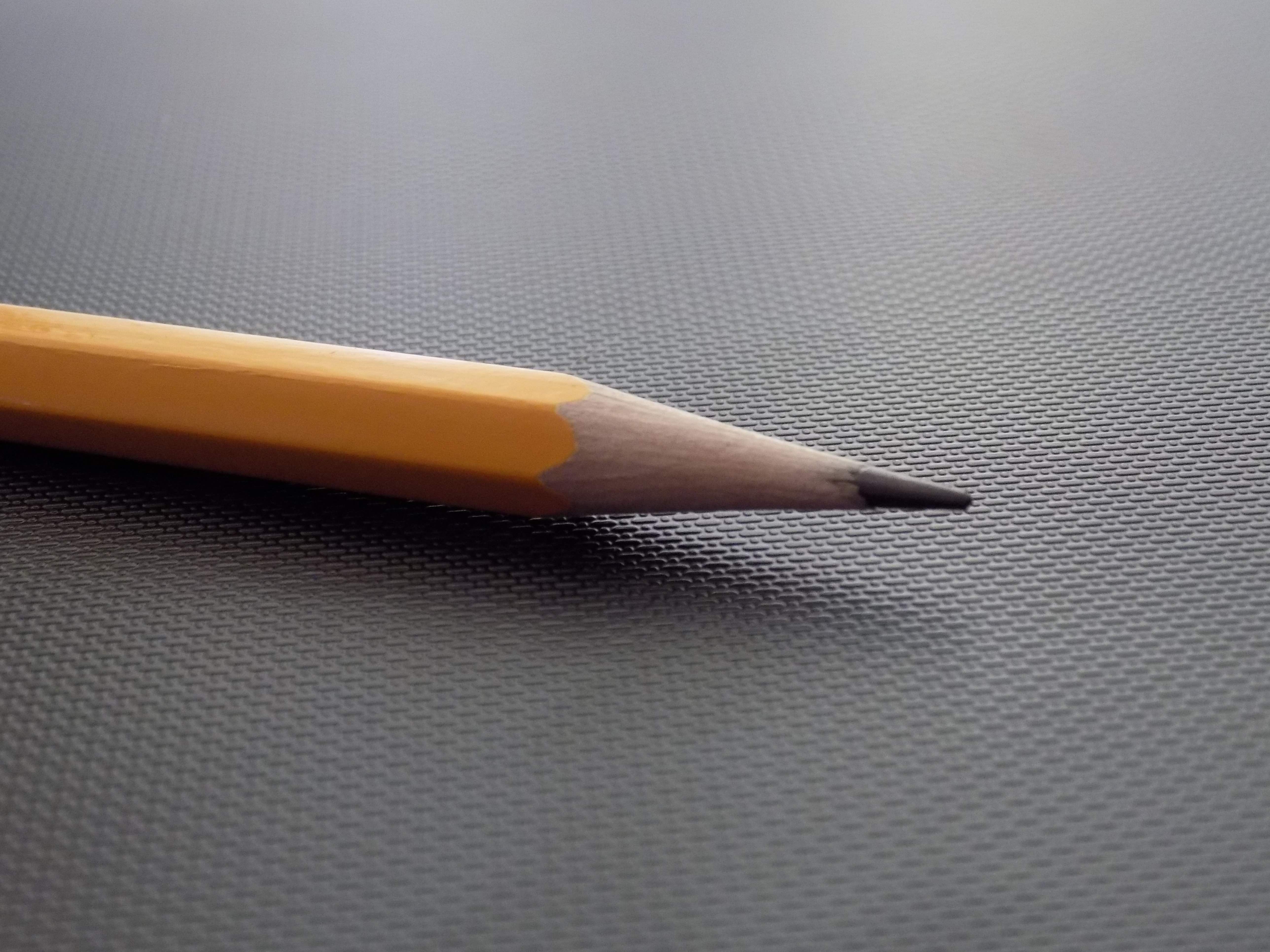 A close-up of the point of a standard pencil with a gray tip.